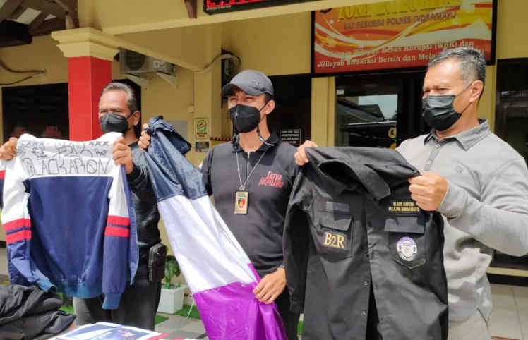 Polisi saat menunjukkan barang bukti berupa atribut anggota geng motor yang melakukan penganiayaan warga di Indramayu, Jawa Barat, Minggu (28/11/2021). (ANTARA/Khaerul Izan)