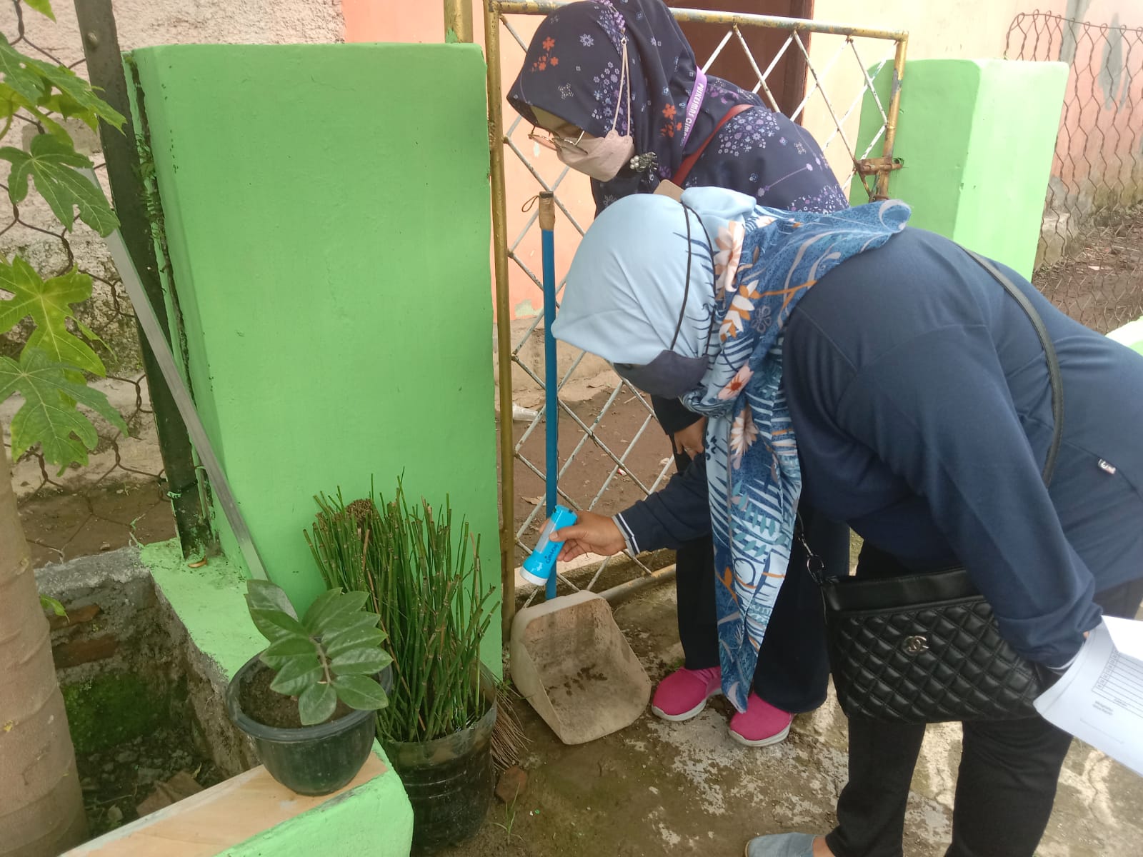 Salah satu petugas kesehatan di kawasan Kelurahan Cimahi sedang lakukan cek pemeriksaan pada pot untuk mengetahui adanya jentik nyamuk, Jumat (19/11). (Intan Aida/Jabar Ekspres)