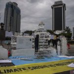 Aktivis Greenpeace Indonesia menggelar aksi di kawasan Monumen Nasional, Jakarta, Rabu (10/11/2021), untuk menyampaikan adanya ancaman besar akibat perubahan iklim. (ANTARA FOTO/Sigid Kurniawan/wsj)