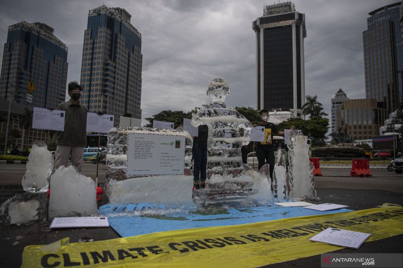 Aktivis Greenpeace Indonesia menggelar aksi di kawasan Monumen Nasional, Jakarta, Rabu (10/11/2021), untuk menyampaikan adanya ancaman besar akibat perubahan iklim. (ANTARA FOTO/Sigid Kurniawan/wsj)