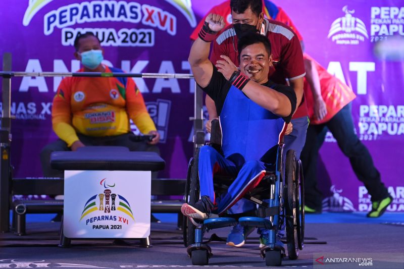 Lifter Jawa Barat Ahmad Hidayat mengepalkan tangan usai melakukan angkatan pada final angkat berat kelas 59 kg putra Peparnas Papua di Hotel Suni Garden Lake, Sentani, Kabupaten Jayapura, Papua, Rabu (10/11/2021). Ahmad Hidayat menyabet medali emas dengan angkatan terbaik 142 kg, medali perak diraih lifter Sumatera Utara, Ali M Arsyad dengan angkatan 126 kg dan medali perunggu diraih lifter Jawa Tengah, Abdul Manaf dengan angkatan 126 kg. ANTARA FOTO/Wahyu Putro A/nym. (ANTARA FOTO/WAHU PUTRO A)