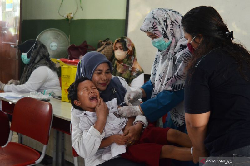 Petugas kesehatan menyuntikkan vaksin kepada siswa Sekolah Dasar (SD) Negeri X Jatiasih di Bekasi, Jawa Barat, Selasa (16/11/2021). Pemberian vaksinasi Difteri Tetanus (DT) dan Tetanus Difteri (TD) kepada siswa tersebut untuk meningkatkan, penguatan, serta kekebalan imun tubuh anak terhadap penyakit. ANTARA FOTO/Suwandy/rwa.