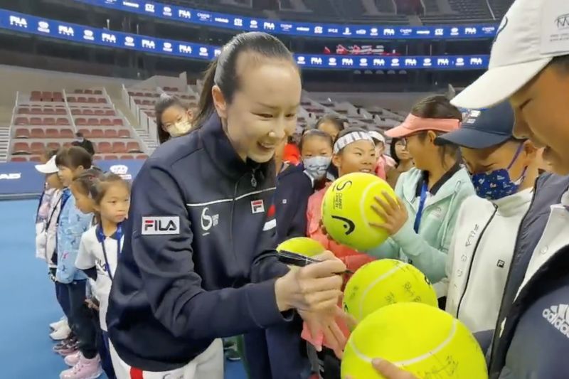 Petenis China Peng Shuai menandatangani bola tenis ukuran jumbo dalam upacara pembukaan kompetisi tenis yunior di Beijing, China, 21November2021(via REUTERS/via TWITTER @QINGQINGPARIS)
