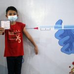 Ilustrasi seorang anak menunjukan kartu vaksin. (ANTARA/Edo Purmana/21