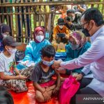 Wali Kota Bogor Bima Arya saat menbantu vaksinasi anak 6-11 tahun yang putus sekolah di Kampung Mongol, Kelurahan Tegallega, Kecamatan Bogor Tengah, Kota Bogor, Rabu (15/12/2021). (ANTARA/HO/Pemkot Bogor)
