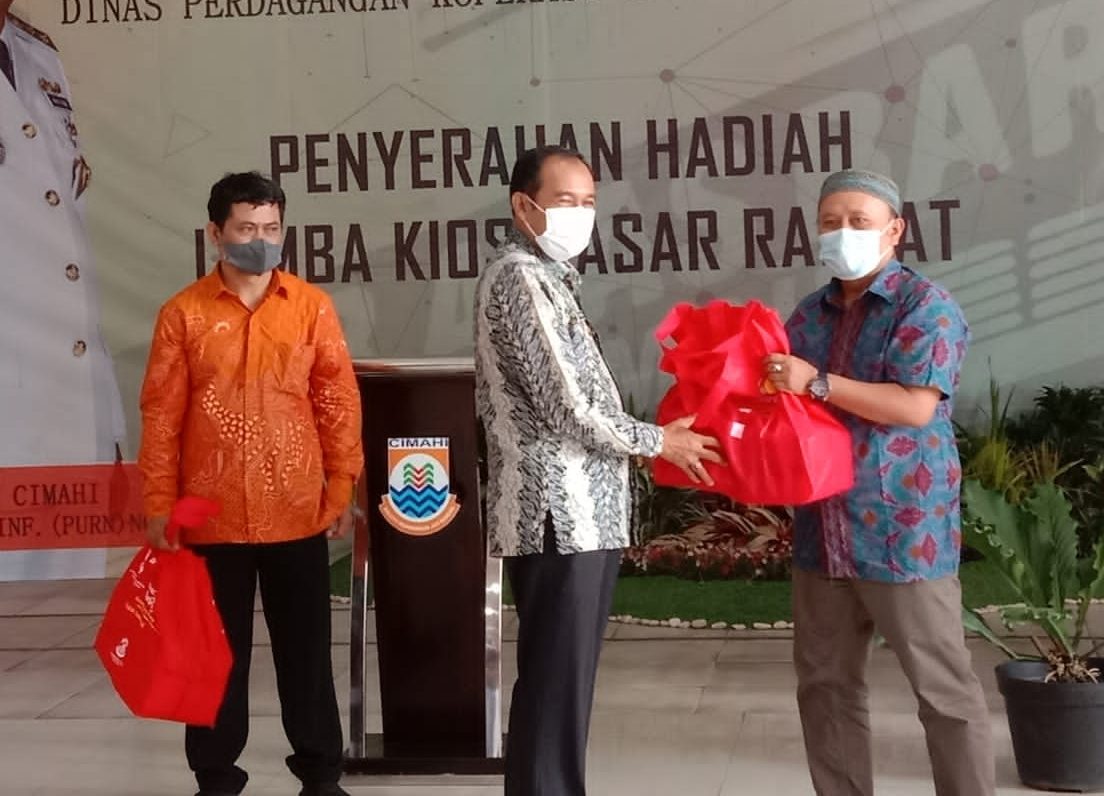 Plt Wali Kota Cimahi Ngatiyana beri hadiah pada dua pedagang yang menang pada lomba kios pasar atas baru, Jumat (24/12). (Intan Aida/Jabar Ekspres)