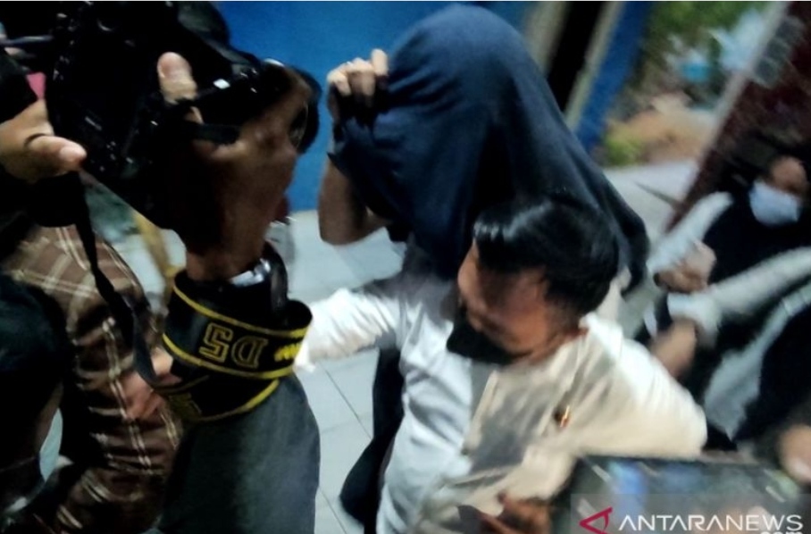Dosen Unsri pelaku pelecehan seksual kepada mahasiswi saat digiring keluar dari ruang penyidikan di Markas Polda Sumatera Selatan pada Senin (6/12/2021). (ANTARA/M Riezko Bima Elko P/21)