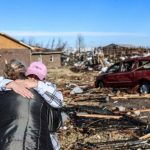 Irene Noltner menghibur Jody O'Neill di luar The Lighthouse, tempat perlindungan wanita dan anak-anak yang dihancurkan oleh tornado bersama dengan sebagian besar pusat kota Mayfield, Kentucky, AS, Sabtu (11/12/2021). ANTARA FOTO/Matt Stone/USA TODAY NETWORK via REUTERS/rwa/sa. (via REUTERS/MATT STONE/USA TODAY NETWORK)