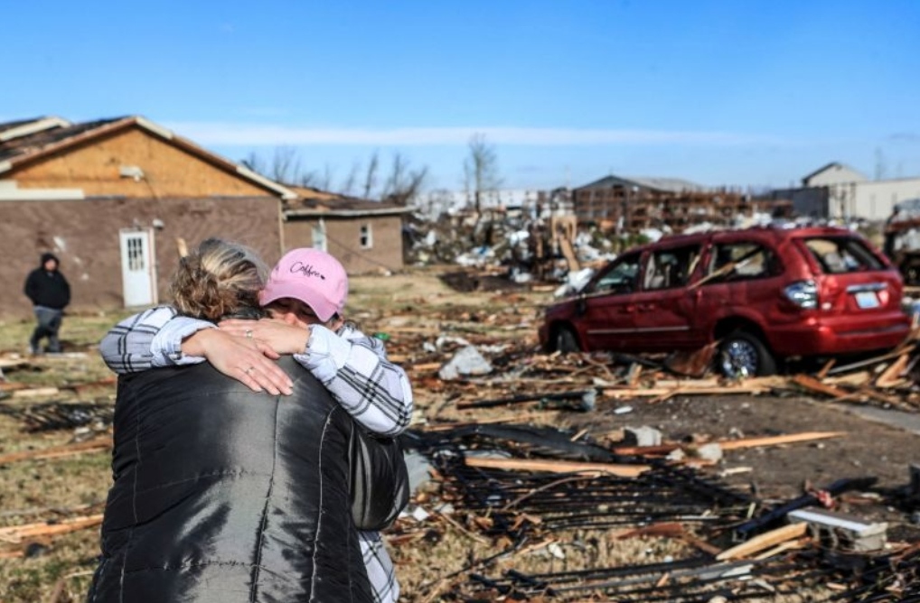 Irene Noltner menghibur Jody O'Neill di luar The Lighthouse, tempat perlindungan wanita dan anak-anak yang dihancurkan oleh tornado bersama dengan sebagian besar pusat kota Mayfield, Kentucky, AS, Sabtu (11/12/2021). ANTARA FOTO/Matt Stone/USA TODAY NETWORK via REUTERS/rwa/sa. (via REUTERS/MATT STONE/USA TODAY NETWORK)