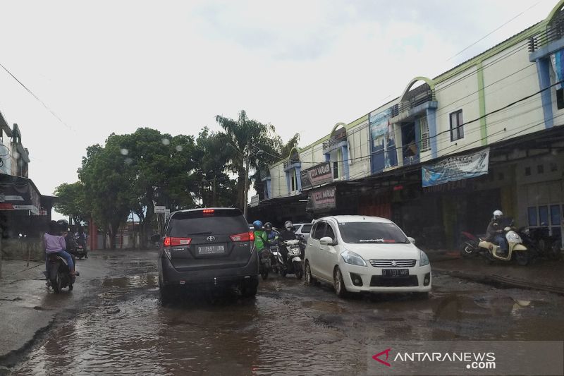 Kendaraan melewati jalan rusak yang tergenang air di Kabupaten Garut, Jawa Barat beberapa waktu lalu. ANTARA/Feri Purnama