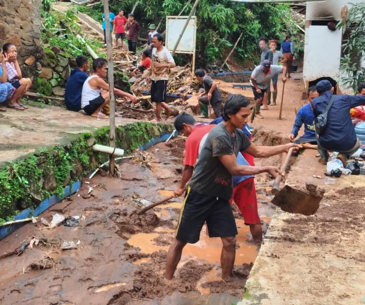 BENCANA: Warga Desa Ciherang saat gotong royong bersihkan material tanah akibat luapan air dan longsor.