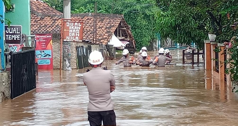 Ilustrasi: Anggota Polres Sumedang saat melakukan evakuasi korban banjir. (Istimewa)