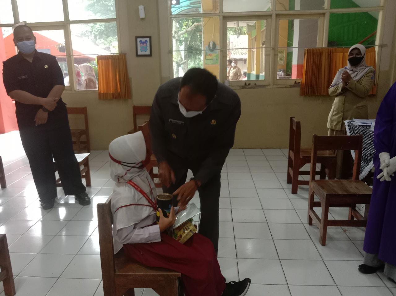 Pada kegiatan vaksinasi anak 6-11 tahun, Plt Wali Kota Cimahi Ngatiyana memberikan semangat pada salah satu siswa SD setelah divaksin.