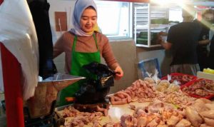 Pedagang ayam potong di Pasar Cimahi sedang melayani pembeli.