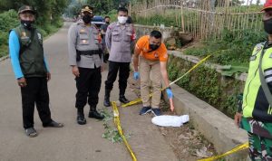 Petugas menunjukkan lokasi ditemukanannya jasad bayi dipinggir jalan Desa Cibiru Wetan Kecamatan Cileunyi.