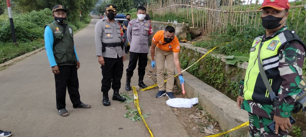 Petugas menunjukkan lokasi ditemukanannya jasad bayi dipinggir jalan Desa Cibiru Wetan Kecamatan Cileunyi.