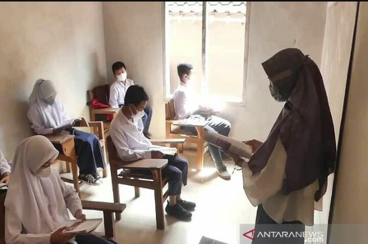 Sejumlah siswa MTs Nurul Huda di Desa Keblukan, Kaloran, Kabupatren Temanggung, Jawa Tengah, Senin (17/1/2022) belajar di rumah warga karena atap ruang kelas roboh. FOTO ANTARA/Heru Suyitno