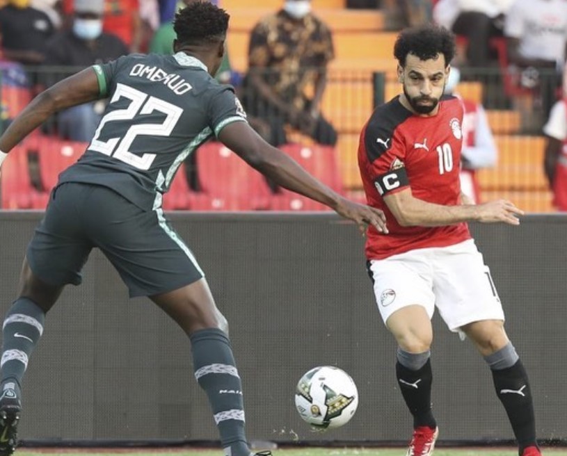 Mohamed Salah (kanan) berusaha melewati pemain Nigeria dalam pertandingan Piala Afrika 2021, beberapa waktu lalu. (@thepharaohs.official/Instagram)