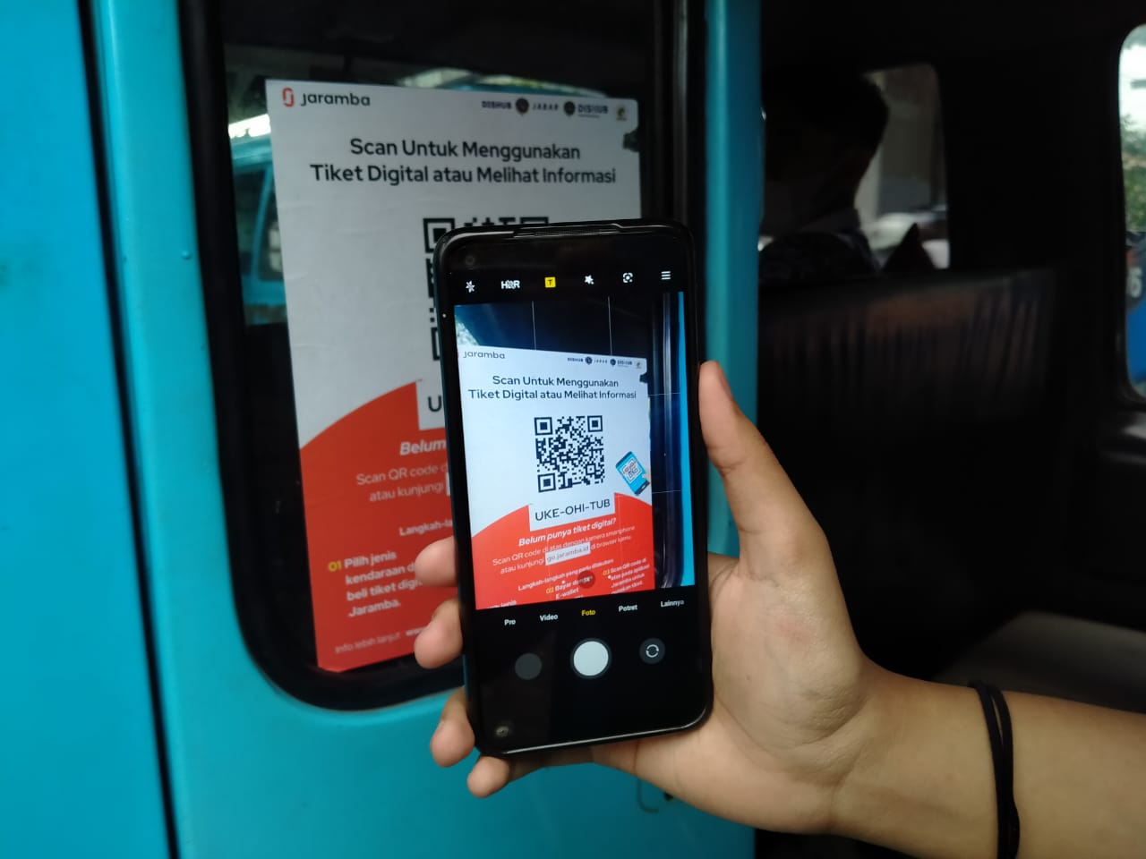 Warga melakukan scan barcode aplikasi Jaramba, di salah satu angkatan umum, Jalan Pasteur, Kota Bandung, Jumat (7/1). (Yuga Hassani/ Jabar Ekspres)