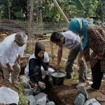 Atlet Angkat Besi asal Kabupaten Bandung, Windy Cantika, saat meletakan sebuah batu dan adukan semen pertama pada bangunan pondasi bangunan masjid, Minggu (30/1).
