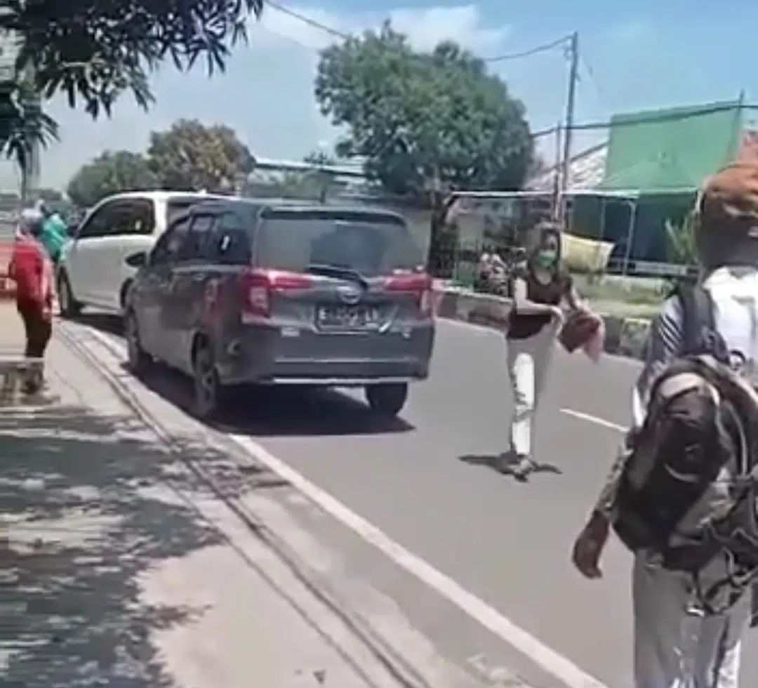 Tangkapan layar video yang viral, seorang wanita yang diduga sebagai pelakor keluar dari sebuah mobil setelah dipergoki oleh istri sahnya, seperti kisah di serial Layagan Putus yang sedang viral.