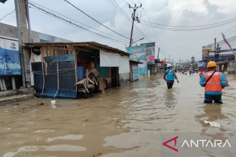 Petugas PT PLN memantau jaringan kelistrikan wilayah terendam banjir di Kampung Pisangan, Babakan, Kecamatan Tambun Utara, Kabupaten Bekasi, Jawa Barat, Kamis (17/2/2022). ANTARA/Pradita Kurniawan Syah