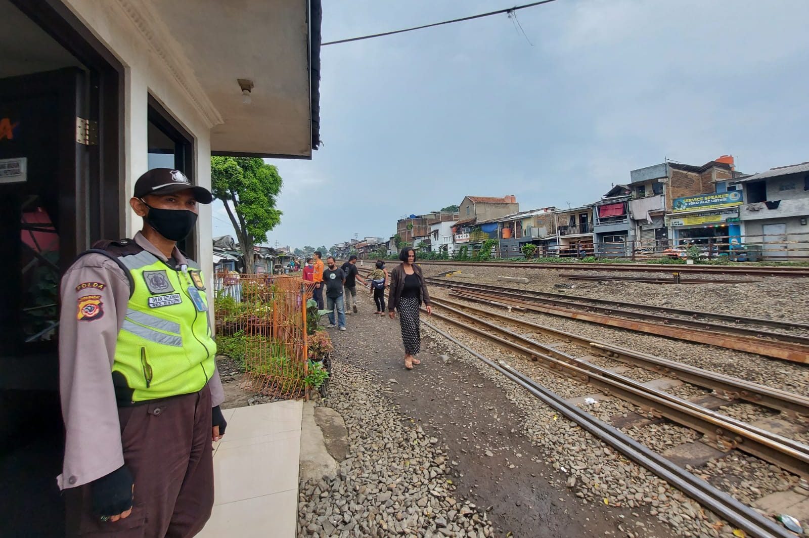 Seorang petugas keamanan sedang mengawasi rel kereta api di Pasar Ciroyom, Rabu (16/02/2022)./ Arvi Resvanty