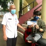 Sekcam Cimanggis, Bambang Eko Sukmono (kiri) menyerahkan kartu KDS sebagai bantuan sosial pada penerimanya, istimewa.