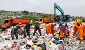 Prajurit TNI bahu-membahu bersama petugas Dinas Lingkungan Hidup Kabupaten Bekasi, Jawa Barat mengangkut sampah di Tempat Pembuangan Sampah liar Kali CBL Desa Sumberjaya, Kecamatan Tambun Selatan, Jumat. (ANTARA/Pradita Kurniawan Syah).