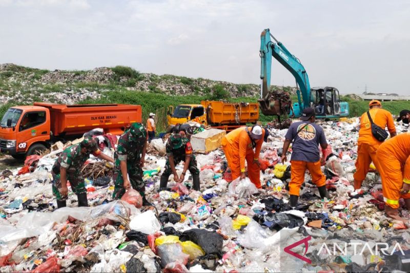 Prajurit TNI bahu-membahu bersama petugas Dinas Lingkungan Hidup Kabupaten Bekasi, Jawa Barat mengangkut sampah di Tempat Pembuangan Sampah liar Kali CBL Desa Sumberjaya, Kecamatan Tambun Selatan, Jumat. (ANTARA/Pradita Kurniawan Syah).