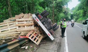 Petugas Kepolisian saat mengamankan lalu lintas pasca kecelakaan tunggal yang menimpa satu unit truk diesel di Jalan Raya Bandung-Cirebon telatnya di area Cadas Pangeran, Kabupaten Sumedang
