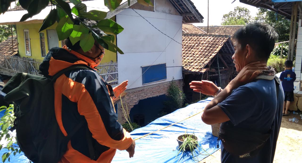 Anggota BPBD Kabupaten Bandung (kiri) saat memeriksa kondisi 3 rumah warga RT02 RW08, Desa Bojong, Kecamatan Nagreg, Kabupaten Bandung yang diterjang longsor. (Jabar Ekspres)