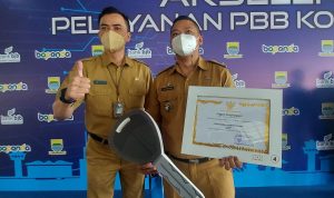 Camat Sumur Bandung, Willy Yudia Laksana dan Lurah Kebon Pisang, Aldi Norman saat penerimaan penghargaan lurah dan camat wajib pajak terbaik, di Summarecon, Bandung, Senin (27/3).