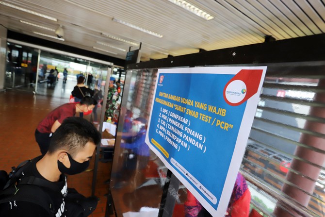 Calon penumpang pesawat menunjukan surat hasil tes PCR di Terminal 2, Bandara Soekarno-Hatta. (Dery Ridwansah/JawaPos.com)