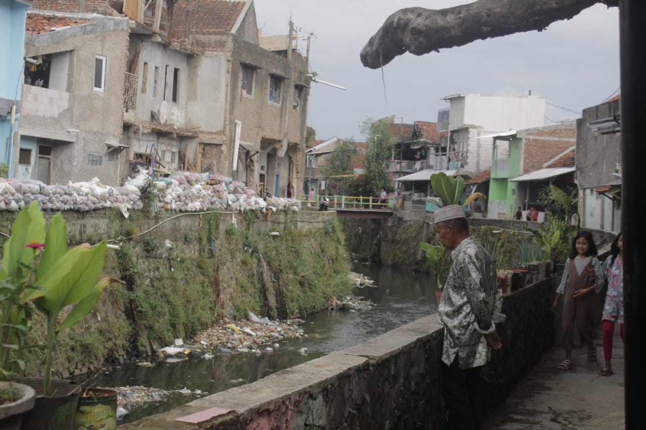 BANTARAN SUNGAI: Seorang warga tengah memperhatikan aliran sungai di Cikapundung Kolot, Kelurahan Gumuruh, Kecamatan Batununggal, Kota Bandung. (Deni/Jabar Ekspres)