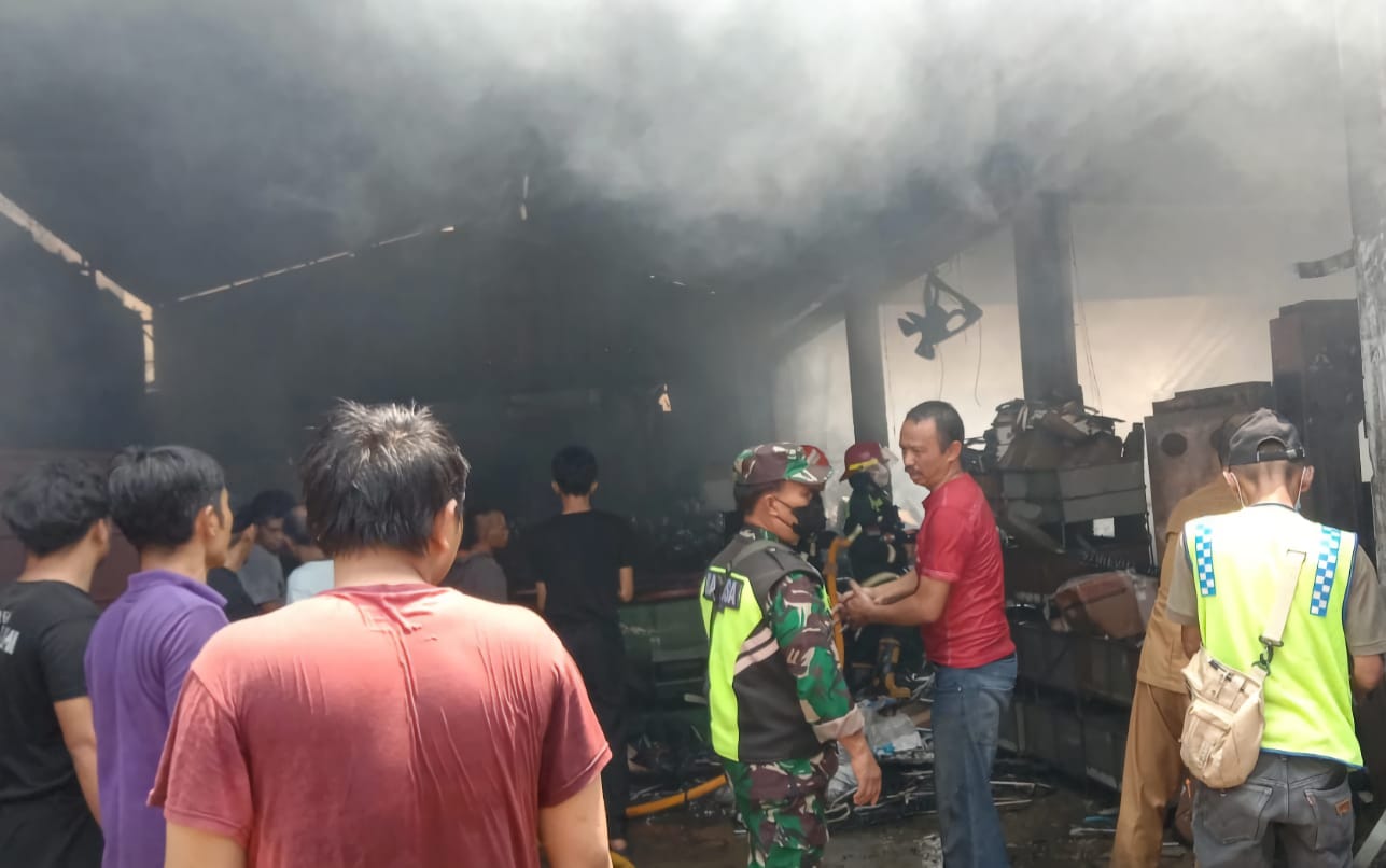 Proses pemadaman api yang melahap gudang perakitan aksesoris sepeda motor oleh berbagai unsur.