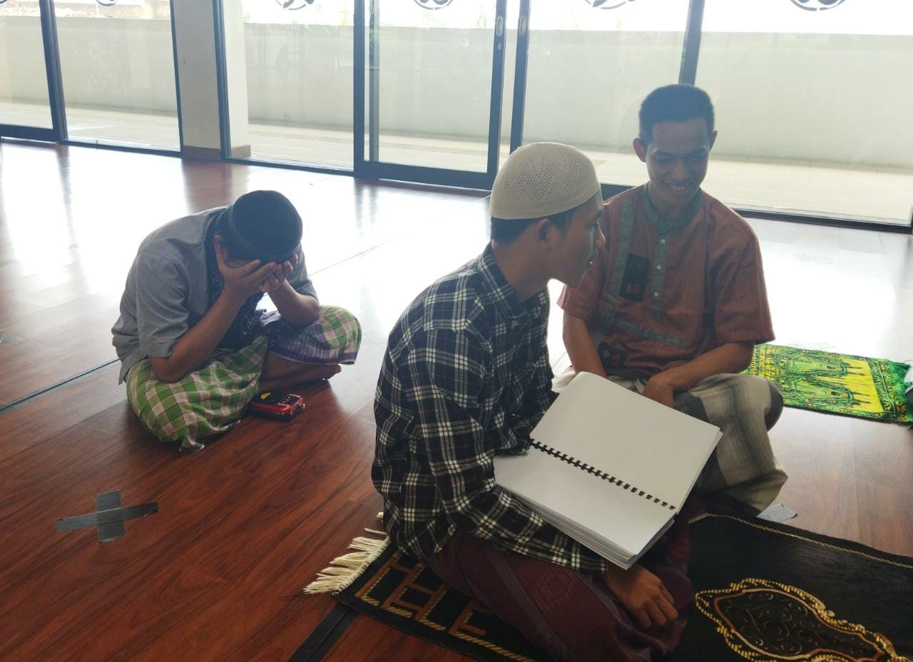 UJIAN: Dua orang santri Pesantren Tunanetra Sam'an tengah menyetor hafalan juz Al-Qur'an kepada Amin Rasyid, 23, penguji hafalan sekaligus hafidz Al-Qur'an Braille sekaligus alumni pesantren yang sedang mengabdi.