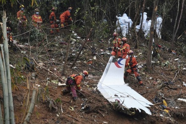 Pekerja mencari melalui puing-puing di lokasi pesawat China Eastren jatuh (Foto: Xinhua News Agency)