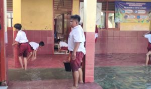 Kondisi sekolah yang terendam banjir, siswa terpaksa membantu menguras air agar bisa melaksanakan ujian. ( FOTO MELIDA ROHLITA/RADARLAMPUNG.CO.ID)