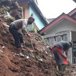 Anggota Kepolisian serta warga tengah membersihkan material tanah pasca TPT di Dusun Haur Koneng, Desa Ciherang, Kecamatan Sumedang Selatan, Kabupaten Sumedang ambrol, Kamis (12/5).