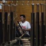 MEMOLES: Perajin angklung, Adang (37) melakukan proses tahap akhir pengecekan nada di ruang perajin Saung Angklung Udjo, Kota Bandung. (Deni/Jabar Ekspres)