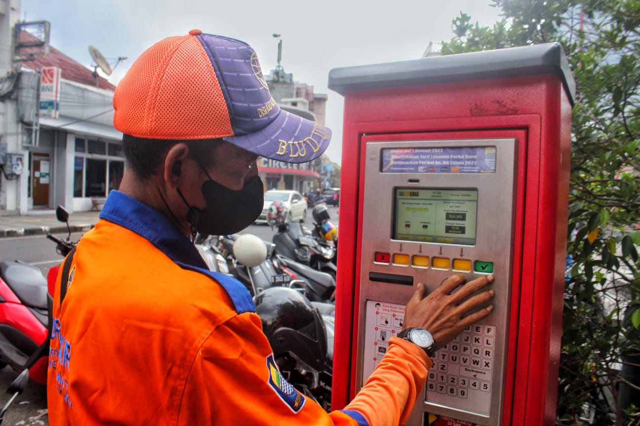 Deni Mulyadi tengah mengoperasikan mesin parkir di Jalan Braga, Senin (30/5). (Deni/Jabar Ekspres)