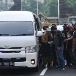 Sejumlah polisi mengamankan kedatangan petinggi organisasi Khilafatul Muslimin, Abdul Qadir Baraja (kiri) saat tiba di Polda Metro Jaya, Jakarta, Selasa (7/6). (Foto: Antara)