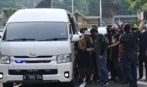 Sejumlah polisi mengamankan kedatangan petinggi organisasi Khilafatul Muslimin, Abdul Qadir Baraja (kiri) saat tiba di Polda Metro Jaya, Jakarta, Selasa (7/6). (Foto: Antara)