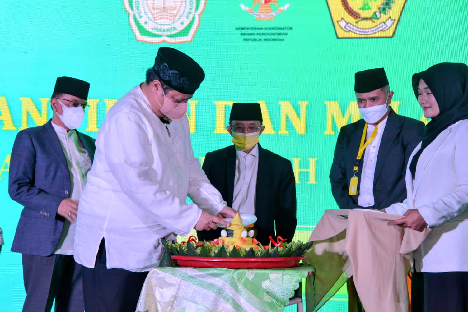 Menko Airlangga Hartarto memotong tumpeng dalam acara hari jadi ke-44 Majelis Dakwah Islamiyah belum lama ini.