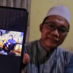 Ahmad, (40), salah satu keluarga Asep Ahmad Solihin, (29), memperlihatkan potret Asep saat duduk di stadion menyaksikan pertandingan dari Persib Bandung. (Deni/Jabar Ekspres)