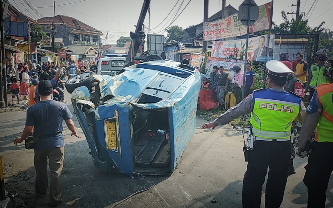 Jajaran Polresta Bogor Kota saat mengevakuasi satu unit angkot yang ringsek tertabrak Commuter Line di pintu perlintasan kereta Kebon Pedes, Kota Bogor, Selasa (30/8). (Yudha Prananda / Jabar Ekspres)