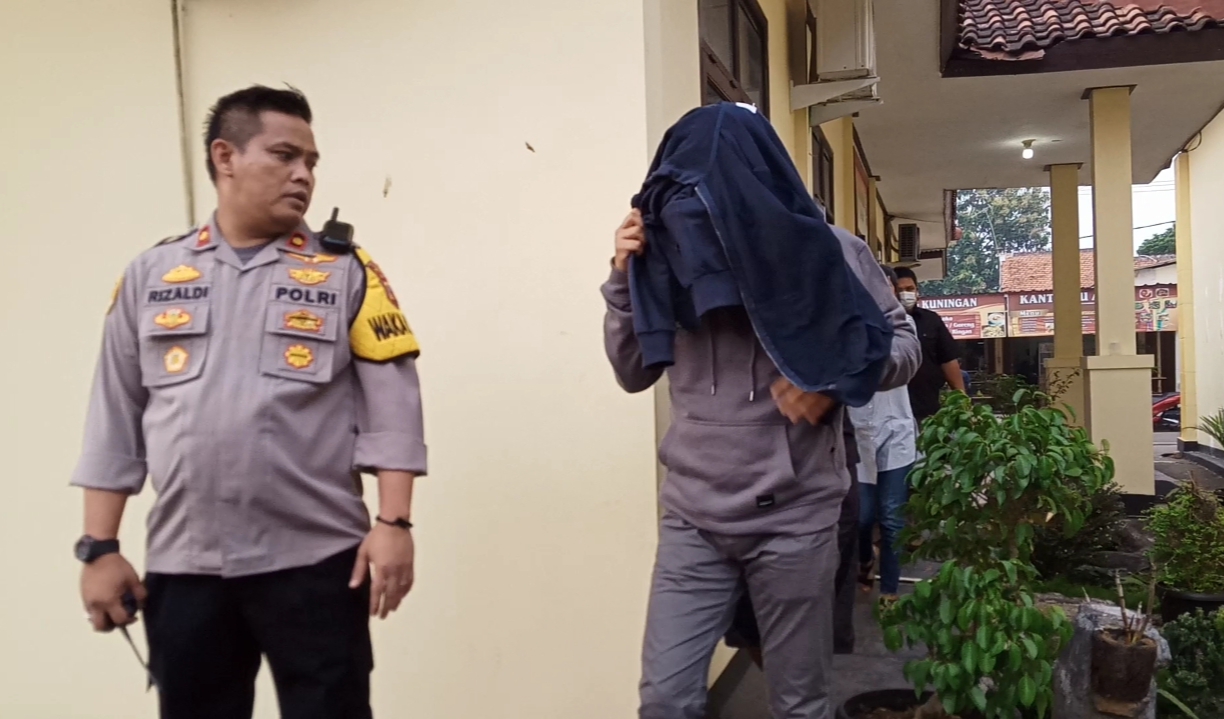 Anggota DPRD Purwakarta yang pesta sabu, saat kelaur dari ruang penyidikan menutup kepalanya menggunakan jaket. (ist)