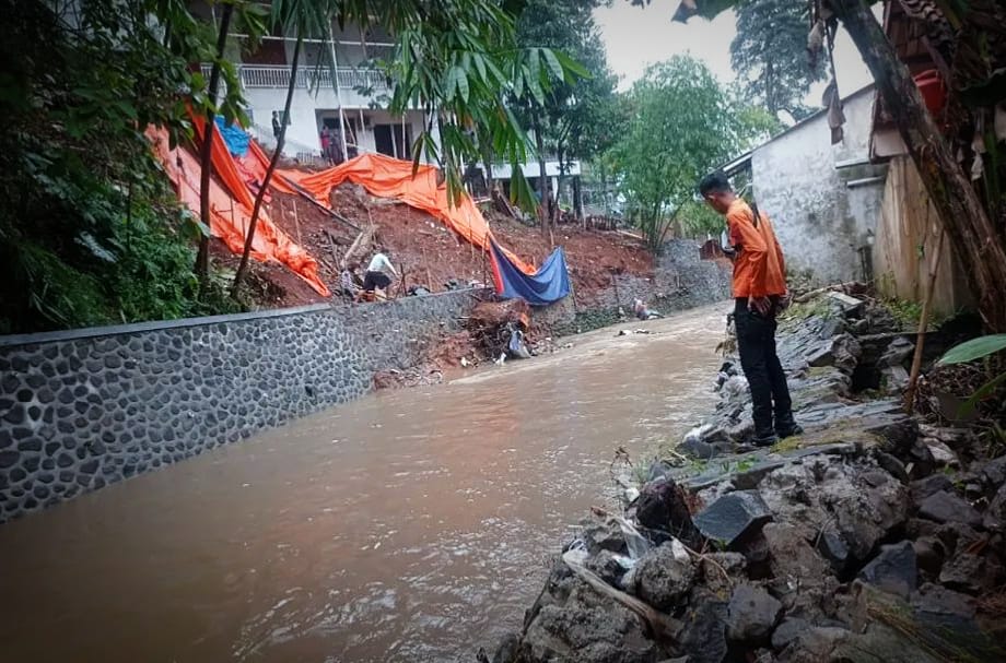 Petugas BPBD Kota Bogor saat meninjau salah satu lokasi yang dilanda longsor. (Yudha Prananda / Istimewa)