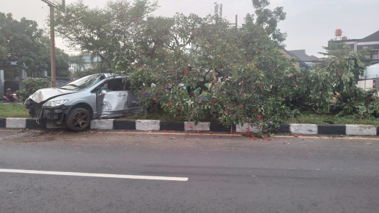LAKA TUNGGAL: Kondisi mobil sedan yang rusak berat usai lompati marka jalan dan menabrak pohon di Jalan Raya Soekarno Hatta. (Yanuar/Jabar Ekspres)